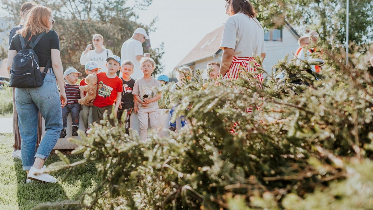 Children and adults participating in an outdoor educational activity surrounded by nature.
